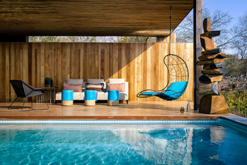 Singita Sweni Lodge: Sofa-Lounge am Pooldeck mit Hängesessel