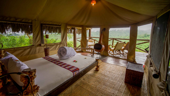 Crater Forest Tented Camp: Luxuriöses Bett mit Waldblumen Dekoration