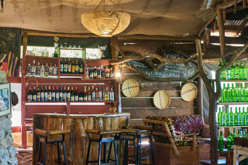 Ikoma Tented Camp: Safari-Bar mit Holztheke und Medaillen