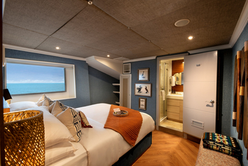 andBeyond Galapagos Explorer: Kabine mit Meerblick und orangem Überwurf