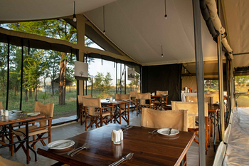 Mara Kati Kati Tented Camp: Eleganter Speisesaal mit Holz- und Canvas-Möbeln