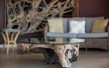 Serondela Lodge: Rattan-Lounge mit skulpturalem Wurzelholz Couchtisch