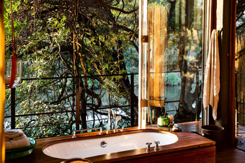 Singita Sweni Lodge: Badezimmer mit Wanne am Waldfluss