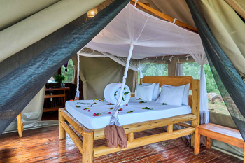 Migunga Tented Camp: Vier-Pfosten Bett mit Moskitonetz und Blumen