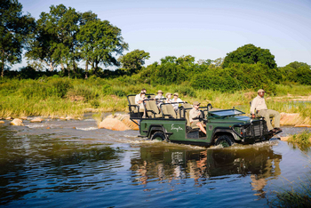 Singita Castleton: Safariwagen durchquert seichten Fluss mit Gästen