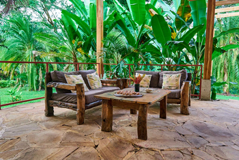 Arusha Safari Lodge: Rustikale Outdoor-Lounge mit Holzmöbeln im Grünen