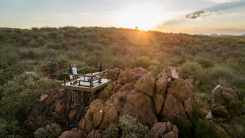Madikwe Hills Private Game Lodge: Gäste bei Sonnenuntergang auf Holzterrasse