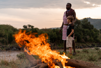 Tangulia Mara Camp: Guide mit Kind am Lagerfeuer