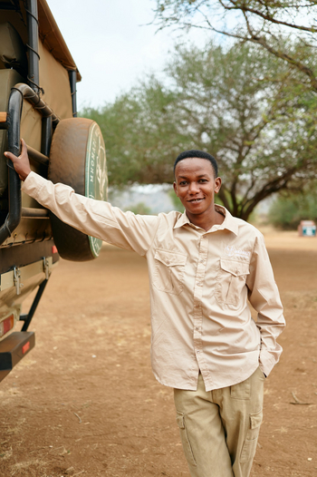 Mkomazi Wilderness Retreat: Lächelnder Guide am Safarifahrzeug im Busch