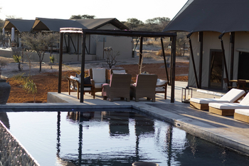 Otjiwa Thornbush Tented Camp: Pooldeck unter Pergola mit Korbsesseln
