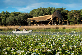 King Lewanika Lodge: Kanu und Lodge im Hintergrund