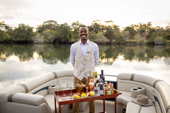 Anantara Tented Camp Kafue River: Butler richtet Sundowner-Bar auf Bootsdeck