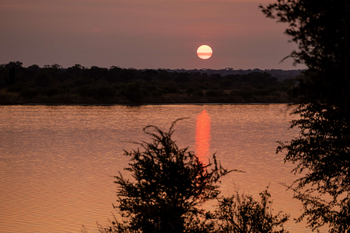 Anantara Tented Camp Kafue River: Goldener Sonnenuntergang über ruhigem Safarifluss