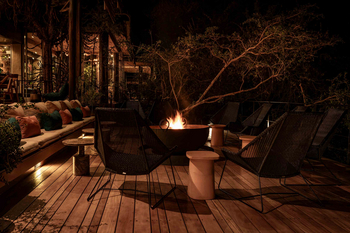 Singita Sweni Lodge: Nächtliches Lagerfeuer mit geflochtenen Loungesesseln
