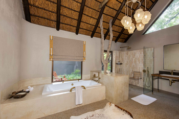 Sabi Sabi Bush Lodge: Freistehende Badewanne mit Messingarmaturen im Bad.
