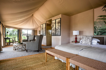 The River Camp: Safarischlafzimmer mit grauen Sesseln und Holzbänken